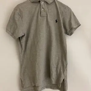 Snygg grå pikétröja från Ralph Lauren med klassisk krage och knappar. Den har en broderad logga på bröstet och är kortärmad. Perfekt för en stilren och avslappnad look. Priset är förhandlingsbart🙌