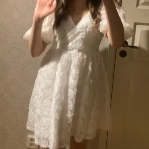 Studentklänning Bubbleroom - Studentklänning från Bubbleroom med vackra blommiga detaljer och puffiga kortärmar. Säljer då jag köpte samma fast i Xs som passade mig bättre. 