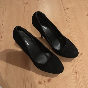 Svarta pumps med klack - Svarta pumps i mocka initiation, använda men fina.