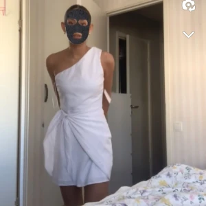 Vit oneshoulder klänning - Helt oanvänd snygg vit oneshoulder klänning med en knytning vid midjan. Perfekt till studenten, midsommaren eller skolavslutning. 