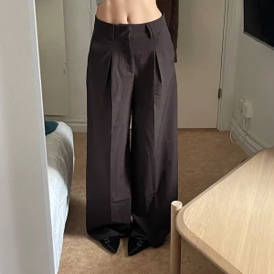 Kostymbyxor - Pösiga mörkbruna kostymbyxor från Bershka i storlek S. Knappt använda så väldigt fint skick. Riktigt bekväma! Jag på bilden är 175cm