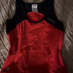 Röd och svart linnetopp från Adidas - Snygg röd och svart linnetopp från Adidas med ribbad textur. Passar xxs-s. Pris kan diskuteras 