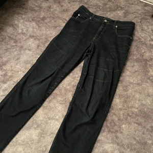 Svarta jeans från Armani Jeans - Snygga mörkblåa jeans från Armani Jeans med klassisk femficksdesign och knappgylf. Perfekta för en stilren look. Köptes på zalando för 1400kr