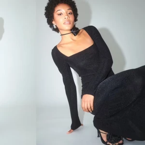 Svart glittrig långklänning - Elegant svartglittrig långklänning. Klänningen har en tight passform och långa ärmar, perfekt för festliga tillfällen eller nyår. Originalpris 500kr. Säljer för 400kr, men kan gå ner i pris vid snabb affär. Klänningen är använd endast en gång, så den är i mycket bra skick. Den är tvättad.