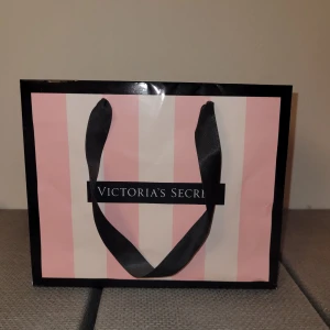 Victoria's Secret bag - Snygg liten påse från Victoria's Secret i rosa och vit randigt mönster med svarta handtag. Perfekt för en shoppingrunda eller som en stilren accessoar. Köparen står för frakten🫶