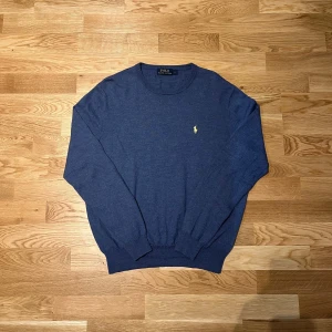 Mörkblå tröja från Polo Ralph Lauren - Säljer en blå tröja från Polo Ralph Lauren med det klassiska broderade logotypen på bröstet. Tröjan har långa ärmar och en rund halsringning. Tröjan är i storlek L men passar även som M. Perfekt för en avslappnad och snygg look.