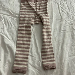 Randiga byxor från Pomp de Lux - Säljer ett par mysiga randiga leggings från Pomp de Lux i storlek 92. Byxorna har en mjuk och bekväm passform med elastisk midja. Perfekta för en avslappnad dag hemma. Varan kommer att tvättas och strykas innan leverans! ⭐️