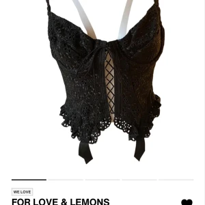 For Love & Lemons - svart korsett med spetsdetaljer och snörning framtill. Den har justerbara axelband och en dragkedja bak. Superfin och unik från for love & lemons.