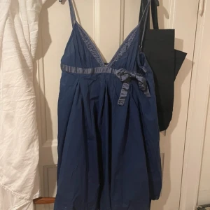 Mörkblå klänning från Miss Sixty - Snygg mörkblå klänning från Miss Sixty med smala axelband och en dekorativ rosett i midjan. Perfekt för en stilren look eller på en varm sommardag.