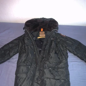 Parajumper jacka utan päls *Bra skick - Säljer en svart parkajacka från Parajumpers med pälsfoder i huvan och flera praktiska fickor. Jackan saknar pälsen som den kom med. Tyvärr har en knapp på jackan gått av men den funkar precis lika bra utan den.                                                              Priset är inte fast