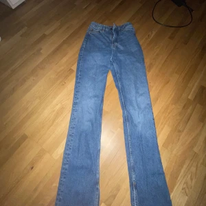 Högmidjade bootcut Jeans - Säljer ett par klassiska blå jeans från H&M Divided. De har en bootcut passform och är perfekta för en avslappnad stil. Jeansen stängs med dragkedja och knapp. Bara använda 1 gång💕💕
