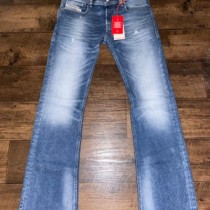 Diesel jeans - Snygga blå jeans från Diesel med en bootcut-stil och midwaist passform. Helt nya och oanvända.