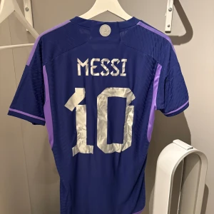 Argentina away jersey Messi 10 - Argentina bortaställ från VM 2022. Messi 10 på ryggen. Authentic version. Köpt på Unisport och har unisports tryck gällande Nummer 10 fram och bak samt Messi namnet. 