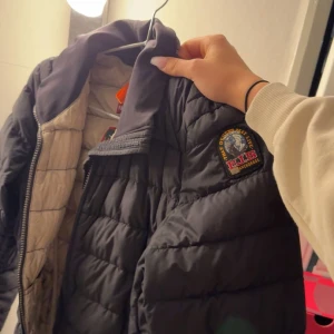 Svart dunjacka från Parajumper - Snygg svart dunjacka från Parajumper med dragkedja och tryck på ärmen. Den är i st XS och självklart äkta.