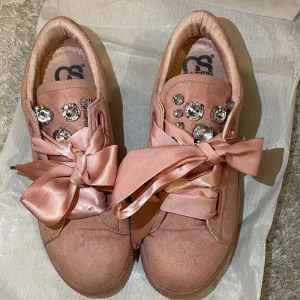 Rosa sneakers med strass och rosetter - Snygga rosa sneakers från Cassis med stora strassdetaljer och breda satinrosetter. Storlek 36-37🎀✨