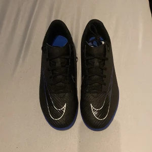 Svarta Nike futsalskor med blå sula - Tjenare 👋🏼•  Säljer dessa fotbollsskor som är perfekta för inomhus då jag endbart använt dom ett fåtal gånger och inte längre har användning av dom• Storlek 42 men passar perfekt till storlek 41 • nypris ligger på 699• mitt pris 350• 👋🏼