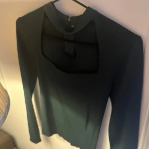 Mörkgrön topp  - Snygg mörkgrön topp med tyg runt halsen och långärmad design. Perfekt för en stilren look. Toppen har en unik öppning vid halsen som ger en extra touch. Populär från zara andra bilden är lånad. Helt nytt skick aldrig använd ❤️❤️