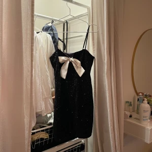 Svart glittrig klänning med rosett - Superfin klänning från hm, helt oanvänd. PERFEKT TILL NYÅR !!!⭐️🌟slutsåld på hemsidan