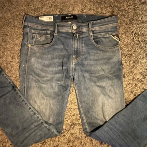 Replay anbass jeans  - Snygga blå jeans från Replay i modellen Anbass. De har en slim fit passform och är tillverkade i deras bekväma Hyperflex-material. Klassisk femficksdesign med dragkedja och knapp. Perfekta för en stilren look. Nypris 1800 