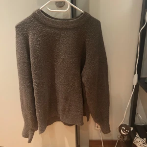 Brun stickad tröja - Mysig brun stickad tröja med långärmad design. Perfekt för kyliga dagar och ger en avslappnad passform. 
