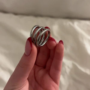 Edblad ring - Säljer en stilren silverfärgad ring med en unik spiraldesign från Edblad i rostfritt stål. Ringen består av flera sammanlänkade band som ger ett modernt och trendigt utseende. Perfekt för att ge din outfit en extra touch av elegans. Ny pris 399 säljer för 150🫶🏻