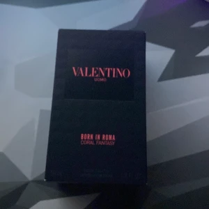 Valentino Uomo Born in Roma Coral Fantasy - Säljer en exklusiv parfym från Valentino, Uomo Born in Roma Coral Fantasy. Flaskan har en lyxig design med ett mönstrat glas och svart kork. Doften är modern och elegant, perfekt för den stilmedvetne. 