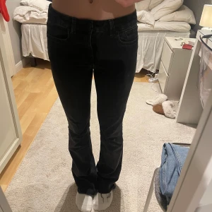 Svarta bootcut jeans från Zara - Snygga svarta bootcut jeans från Zara med låg midja. Perfekta för en stilren look. Tillverkade i ett bekvämt material som ger en skön passform.