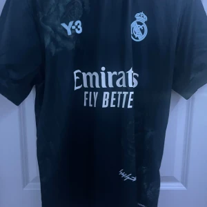 Svart Real Madrid fotbollströja - Snygg svart Real Madrid tröja från Y-3. Aldrig använd förutom testad. Sitter bra. L men skulle kunna passa M för lite mer Baggy fit. Vid snabba affärer kan jag sänka priset 