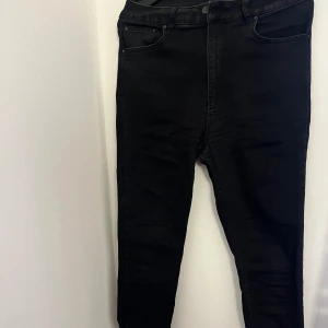 Svarta jeans från Nelly  - Snygga svarta jeans från NLY Jeans. De är ganska skinny och nertill har de en slits. Strl L, köpta för 459 kr