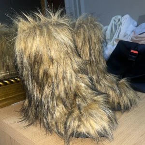 Bruna pälsboots - Säljer ett par unika bruna boots med pälsdetaljer. Perfekta för att göra ett statement i vintergarderoben. De har en fluffig och varm design som sticker ut.