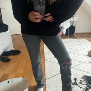 Zara raka gråa  jeans med hål på knäna - Snygga grå jeans med slitna knän och en tight passform. Perfekta för en avslappnad stil med en cool edge. De har en klassisk femficksdesign och är tillverkade i ett bekvämt denimtyg.