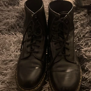 Svarta boots från Dr. Martens - Säljer ett par klassiska svarta Dr. Martens boots med snörning och den ikoniska gula sömmen runt sulan. hållbara för alla väder. Dessa skor håller i evighet 