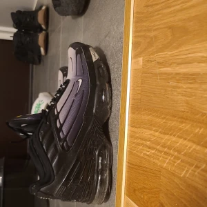 Nike Air Max Plus i svart och lila - Snygga Nike Air Max Plus sneakers i svart och lila med synlig Air Max-dämpning. Skorna har snörning och en modern design som passar perfekt för en sportig look. Dem sitter lite litet så om man har 42 e dem perfekt dem blir bättre efter ett tag