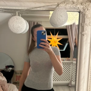 Grå tight t-shirt - Säljer en enkel och stilren grå t-shirt med korta ärmar. Perfekt för en casual look och lätt att matcha med olika outfits.