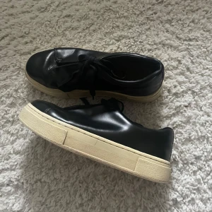 Eytys skor - Snygga svarta sneakers med vit sula och snörning. Perfekta för en avslappnad stil. Skorna har en klassisk design med en bekväm passform. Nypris: 2000kr storlek: 40