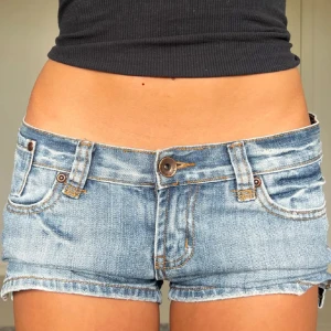 Blå jeansshorts från Only - Snygga blå jeansshorts från Only med låg midja och klassisk femficksdesign. Perfekta för varma sommardagar. De har en knapp och dragkedja framtill samt bälteshällor. Bilder av förra ägaren.