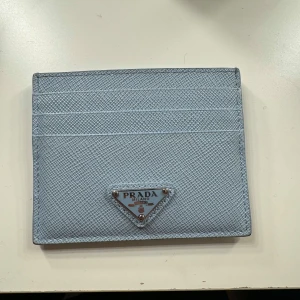 Ljusblå plånbok från Prada - Snygg och stilren baby blue plånbok från Prada, köpt för ett år sedan🩵Perfekt för att hålla dina kort och inga synliga tecken på användning. Kommer i originalförpackning, har tyvärr inget kvitto men allt annat finns. Köpte den för 3999, säljer för 2500.