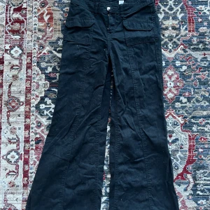 Lågmidjade bootcut jeans! - Svart lågmidjade bootcut jeans, från H&M. Byxorna har praktiska fickor framtill och knäppning med dragkedja. I storlek xs! Använda en gång så i mycket bra skick, lite skrynkliga med det går att stryka bort. Perfekta för en trendig look.