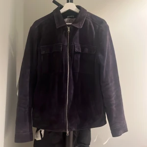 Mörkblå mockajacka från Human Scales - Snygg mörkblå mockajacka från Human Scales i storlek L. Jackan har en dragkedja framtill och två bröstfickor med lock. Tillverkad av 100% koskinn med polyesterfoder. Inköpt för 3000 kr på brothers för ca 1 år sedan. Toppskick. Pris kan förhandlas.