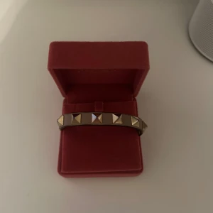 Valentino armband  - Valentino armband med guldiga nitar. Det finns teckning på användning där man justerar armbandet, men inte som man ser när man har på sig det. Nypris är cirka 3000kr  