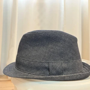 Mörkblå hatt från Nudie Jeans Co - Mycket fin Jeans Hatt från Nudie Jeans!  Köpt i New York på Nudie Jeans Repair Shop. Mycket svår modell att få tag idag! Cool som fan men mitt huvud har blivit större med åren :)  Hör av dig för snabb affär så kan pris sättas ned lite grann, men detta är ett fint samlarobjekt för alla som gillar Nudie!   Finns på Södermalm! Swish accepters. 