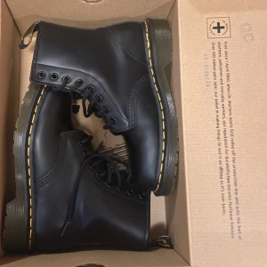 Svarta boots från Dr. Martens - Klassiska svarta Dr. Martens boots med gul söm och snörning. Tillverkade i slitstarkt skinn med en robust sula för extra komfort och hållbarhet. Det är helt oanvänd🩷
