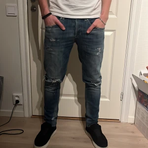 Dondup jeans  - Säljer ett par blåa jeans med  slitningar och en klassisk femficksdesign. De är modellen dondup George. Nypris runt 3000. Modellen på bilden är 180. Storlek 31. 