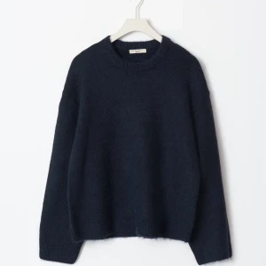 Mörkblå stickad tröja  - Säljer en stilren mörkblå stickad tröja. Tröjan har en klassisk rund hals och långa ärmar, perfekt för kyligare dagar. Den är mjuk och bekväm, idealisk för både vardag och avslappnade tillfällen.