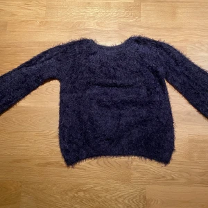 Mörkblå fluffig tröja från Zara - Säljer en supermjuk och fluffig mörkblå tröja från Zara Knitwear, perfekt för vintern. Tröjan har långa ärmar och en mysig textur som håller dig varm och stilren. Från deras vinterkollektion.