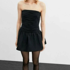 Svart ballong klänning - Snygg svart axelbandslös klänning med rynkad överdel och kort kjol. Använd två gånger så i jätte bra skick 