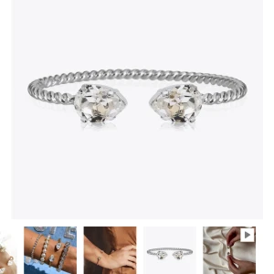 Caroline Svedbom armband - Elegant silverarmband från Caroline Svedbom med två stora, gnistrande kristaller. Armbandet har en tvinnad design som ger en lyxig känsla. Perfekt för att lägga till lite glamour till din outfit. I nyskick!💕