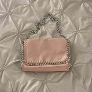 Rosa väska från Tiamo - Snygg rosa axelväska från Tiamo med kedjedetaljer. 