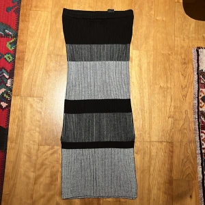 Svart randig tjol från Monki - En svart och grå lång tjol med tjockare material, köpt från Monki. Den är i väldigt nytt skick och har bra kvalitet.