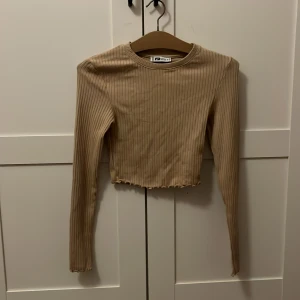 Beige ribbad topp från FB Sister - Säljer en beige topp från FB Sister i storlek S. Den är knappt använd och den är i bra skick också ❤️